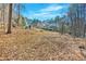 A distant view of the home across a wide open backyard in a wooded setting at 239 Trail Nw Rd, Marietta, GA 30064