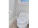 Modern bathroom featuring a white toilet, beige tile flooring, and natural light from the window at 239 Trail Nw Rd, Marietta, GA 30064