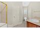 Bright bathroom featuring a shower with glass door, beige tile, toilet and vanity at 239 Trail Nw Rd, Marietta, GA 30064