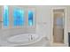 Stunning bathroom with soaking tub, decorative window, and walk-in shower at 239 Trail Nw Rd, Marietta, GA 30064