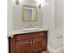 Traditional powder room with wooden vanity, white countertop, gold fixtures, and decorative mirror at 239 Trail Nw Rd, Marietta, GA 30064