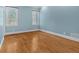 Empty bedroom with hardwood floors, blue walls, white trim, and bright windows at 239 Trail Nw Rd, Marietta, GA 30064