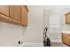 Laundry room featuring hardwood cabinets, tile flooring, and a bright window at 239 Trail Nw Rd, Marietta, GA 30064