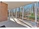 Covered porch with brick columns, offering a serene view of the wooded backyard at 239 Trail Nw Rd, Marietta, GA 30064
