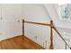 Bright staircase featuring wooden handrail, white spindles, hardwood floors, and natural light from a window at 239 Trail Nw Rd, Marietta, GA 30064