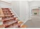 Traditional carpeted staircase leading to a finished basement with a cozy fireplace at 239 Trail Nw Rd, Marietta, GA 30064