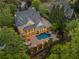 Aerial view of a beautiful house with a private pool, stone patio, and mature trees at 2480 Flint Creek Dr, Cumming, GA 30041