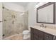 Modern bathroom with stone and glass shower, a large vanity with storage, and neutral colored walls at 2480 Flint Creek Dr, Cumming, GA 30041