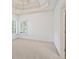 Bright bedroom with white trim, tray ceiling, and window shutters at 2480 Flint Creek Dr, Cumming, GA 30041