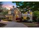 Elegant home with stone accents, an arched porch, and meticulously maintained landscaping at 2480 Flint Creek Dr, Cumming, GA 30041