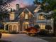 Charming two-story home featuring a stone facade, arched entryway, manicured landscaping, and a circular driveway at 2480 Flint Creek Dr, Cumming, GA 30041