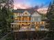 Beautiful home with a covered patio, outdoor lighting, and a pool surrounded by lush greenery at 2480 Flint Creek Dr, Cumming, GA 30041