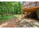 Spacious backyard with a stone patio, wooden deck, lush greenery, and mature trees at 2981 Cardinal Lake Dr, Duluth, GA 30096