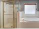 Bright bathroom featuring walk-in shower, soaking tub, and white tile at 2981 Cardinal Lake Dr, Duluth, GA 30096