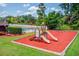 Playground featuring a slide, swings, green grass, and colorful mulch at 2981 Cardinal Lake Dr, Duluth, GA 30096