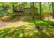 Beautiful backyard, surrounded by lush green trees, with a charming firepit in the grass at 3925 Rock Mill Pkwy, Marietta, GA 30062