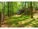 Expansive backyard with mature trees, a fire pit, and a wooden fence creating a private oasis at 3925 Rock Mill Pkwy, Marietta, GA 30062