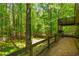 A backyard with a patio and balcony, overlooking a large yard and trees beyond the fenced perimeter at 3925 Rock Mill Pkwy, Marietta, GA 30062