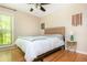 Comfortable bedroom with wood floors, a modern bed frame, and a window with natural lighting at 3925 Rock Mill Pkwy, Marietta, GA 30062