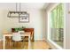 Dining room with modern light fixture, hardwood floors, and a large window with backyard views at 3925 Rock Mill Pkwy, Marietta, GA 30062