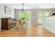 Bright dining room with hardwood floors, modern light fixture, and views of the wooded backyard at 3925 Rock Mill Pkwy, Marietta, GA 30062