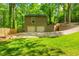 Two-car garage, stairs leading to a deck, driveway, and well-manicured lawn surrounding the property at 3925 Rock Mill Pkwy, Marietta, GA 30062