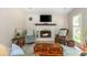 Cozy living room features a stone fireplace, hardwood floors, and comfortable seating arrangement at 3925 Rock Mill Pkwy, Marietta, GA 30062