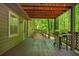 A covered outdoor patio with a grill overlooking a backyard with a fenced perimeter and lush trees at 3925 Rock Mill Pkwy, Marietta, GA 30062