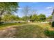 Expansive back yard featuring a well-maintained lawn, mature trees, decorative fencing, and gazebo at 317 Ellenwood Dr, Bowdon, GA 30108