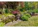 Lush backyard featuring a serene pond with lily pads, rock features, and an inviting bench at 317 Ellenwood Dr, Bowdon, GA 30108