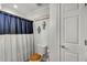 Contemporary bathroom with a blue and white shower curtain and wooden toilet seat at 317 Ellenwood Dr, Bowdon, GA 30108