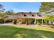 Charming tan home featuring a lush green lawn and a convenient covered carport at 317 Ellenwood Dr, Bowdon, GA 30108