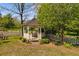 Quaint white gazebo nestled in the backyard and surrounded by lush greenery and decorative fencing at 317 Ellenwood Dr, Bowdon, GA 30108