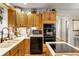 Efficient kitchen layout with black appliances, wooden cabinets, and tile flooring at 317 Ellenwood Dr, Bowdon, GA 30108