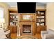 Cozy living room featuring a brick fireplace, built-in wooden shelving, and decorative accents at 317 Ellenwood Dr, Bowdon, GA 30108