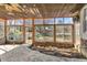 Sunroom with stone base and multiple windows overlooking the backyard and the nature surrounding the property at 317 Ellenwood Dr, Bowdon, GA 30108