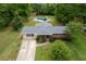 An aerial view shows home with pool and shed surrounded by mature trees in a large green yard and long driveway at 3833 Coral Ln, Douglasville, GA 30135