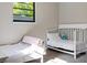 Bright bedroom featuring two twin beds, plush carpets, and a sunlit window for a cozy atmosphere at 3833 Coral Ln, Douglasville, GA 30135