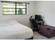 Neutral bedroom with a cozy bed, a wooden desk, and a black-trimmed window at 3833 Coral Ln, Douglasville, GA 30135