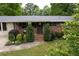 Charming home featuring a well-manicured lawn, mature trees, and neat landscaping in the front yard at 3833 Coral Ln, Douglasville, GA 30135