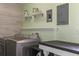 Well-equipped laundry room with modern washer, dryer, ample shelving and a stylish wood-look accent wall at 3833 Coral Ln, Douglasville, GA 30135
