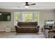 Bright living room with a bay window, ceiling fan, wood-look flooring, and a comfortable couch at 3833 Coral Ln, Douglasville, GA 30135