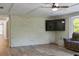 Spacious living room with painted brick accent wall, wood-look floors, and a ceiling fan at 3833 Coral Ln, Douglasville, GA 30135
