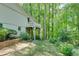 Spacious backyard view showing the home exterior with a balcony, landscaping, and trees at 3990 Admiral Dr, Chamblee, GA 30341