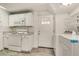 Well-lit kitchen with white appliances, cabinetry, and direct access to laundry area at 3990 Admiral Dr, Chamblee, GA 30341