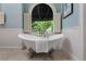 Close up of a clawfoot bathtub with an arched window view of greenery at 4223 Wieuca Overlook Ne, Atlanta, GA 30342