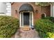 A welcoming front entrance featuring a brick facade, elegant black front door and lush, green landscaping at 4223 Wieuca Overlook Ne, Atlanta, GA 30342
