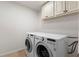 Functional laundry room featuring side-by-side washer and dryer with overhead cabinets at 4223 Wieuca Overlook Ne, Atlanta, GA 30342