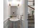 Elegant powder room with pedestal sink, decorative sconces, and stylish wainscoting near a staircase at 4223 Wieuca Overlook Ne, Atlanta, GA 30342