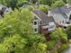 Rear view of brick home surrounded by mature trees, showcasing a deck and well-manicured landscaping at 4223 Wieuca Overlook Ne, Atlanta, GA 30342